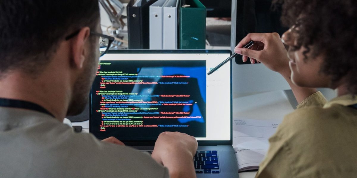 Software engineering team reviewing code together in a modern office