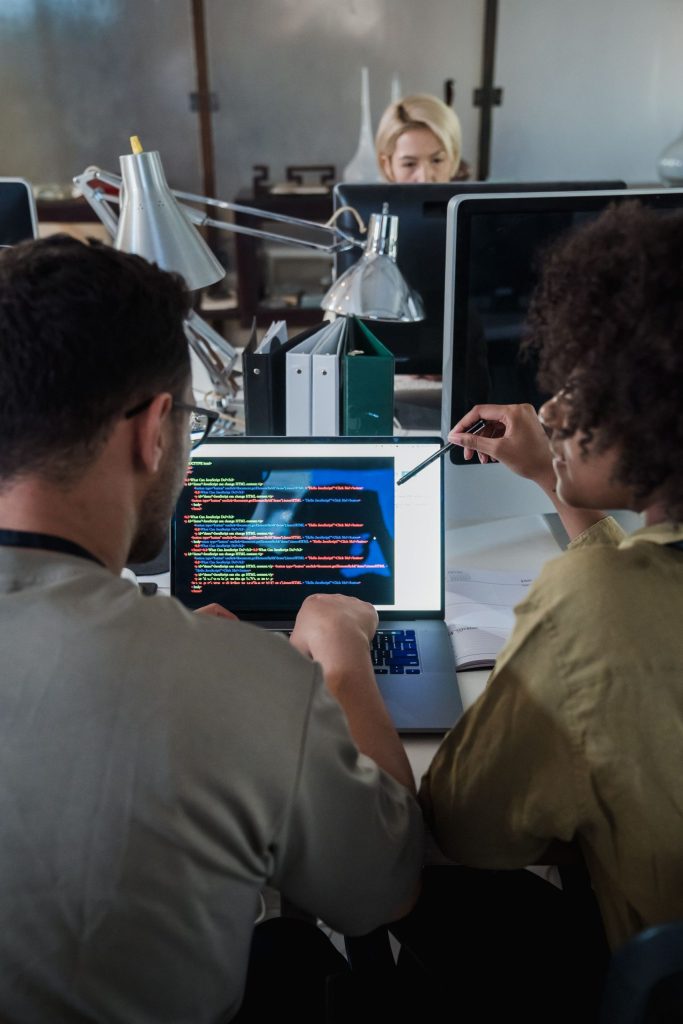 Software engineering team reviewing code together in a modern office